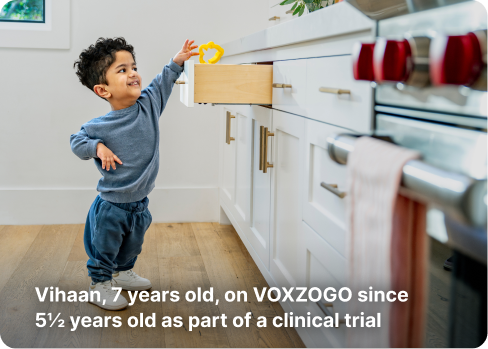 Young child with achondroplasia who is on VOXZOGO treatment, reaching into a kitchen drawer